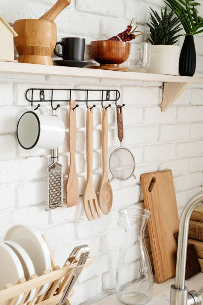 istock Kitchen utensils on black metal hanger in a rustic kitchen 1295936612