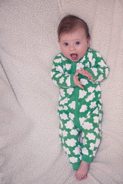 istock cute little baby playing with hands and smiling 1295936822