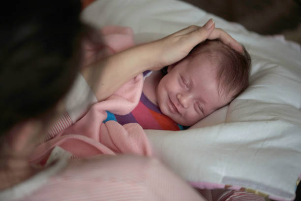 istock new born baby sleeping and in dreams smillling 1295937235