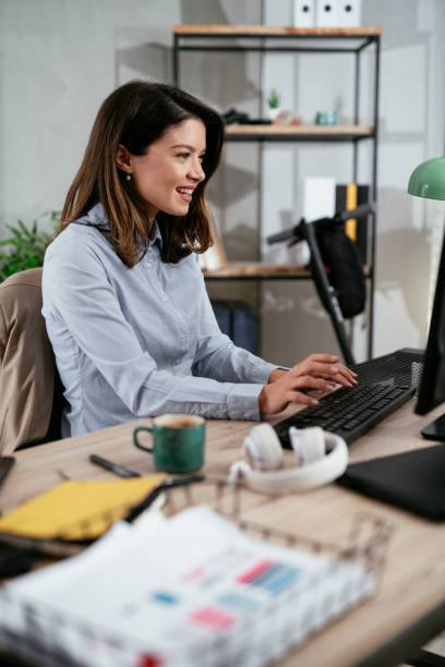 istock Beautiful young woman working on computer at her workplace 1295938217