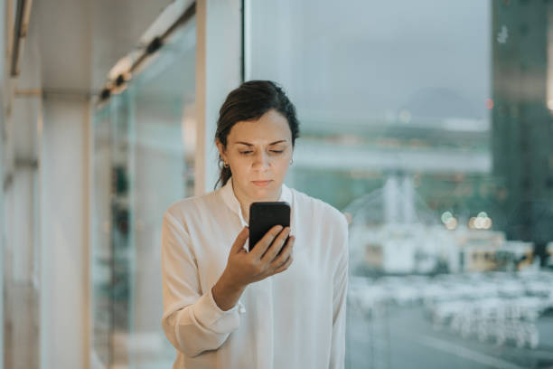 istock Woman using smartphone at the airport 1295939158