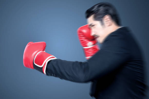 istock Asian businessman with red boxing gloves fighting 1295939232