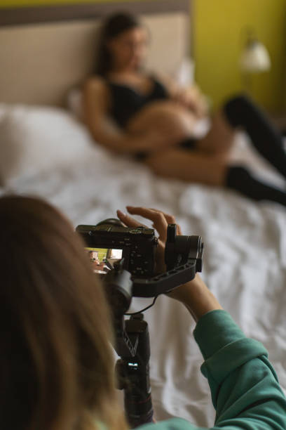 видеооператор женщина съемки на съемочной площадке с беременной женщиной - home video camera women videographer digital video camera стоковые фото и изображения
