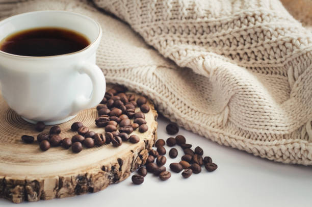 White cup of black hot coffee drink and coffee beans