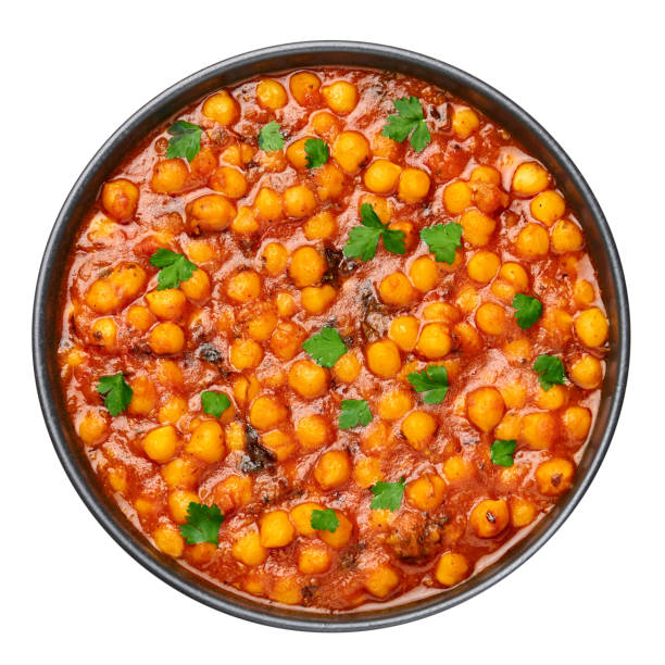 istock Chana Masala or Chole in black bowl isolated on white. Indian cuisine veg chickpeas curry dish. Asian spicy vegetarian food and meal. Top view 1295943708