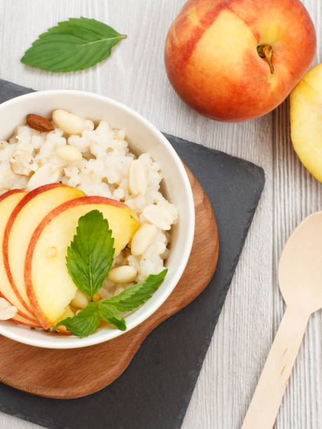 istock Sorghum salad with nuts and fresh peach on stone board. 1295944706