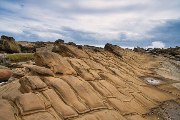 istock Yellow rocks with many textures are located on the seashore. 1295945797