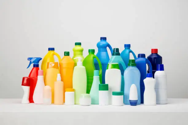 Still life of different types of plastic packaging on white and grey set arranged by colours