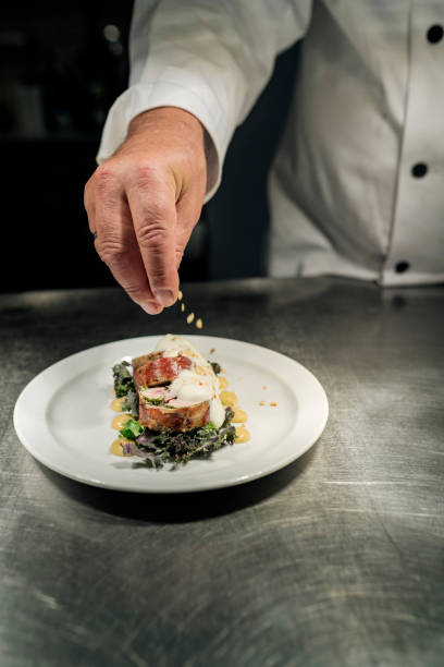 istock Chef adding the final fourish to a meat course of pheasant at the pass. 1295947111