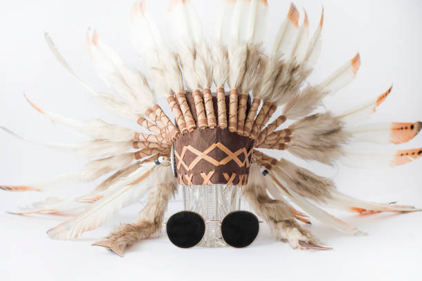 istock Indian hat with feathers on a crystal vase and sunglasses. 1295948220