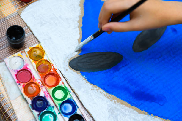 istock a girl drawing blue gouache cardboard, artistic creation at home, makes creative artwork 1295948504