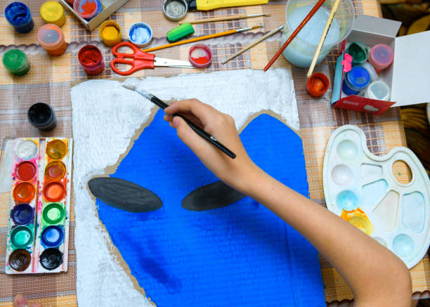 istock a girl drawing blue gouache cardboard, artistic creation at home, makes creative artwork 1295949086