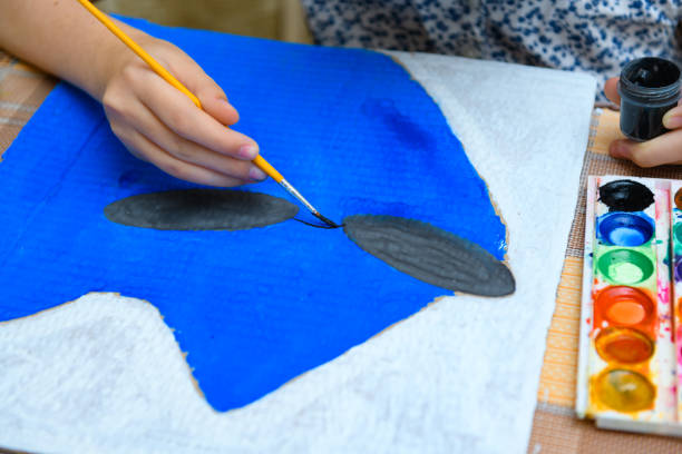 istock a girl drawing blue gouache cardboard, artistic creation at home, makes creative artwork 1295949109