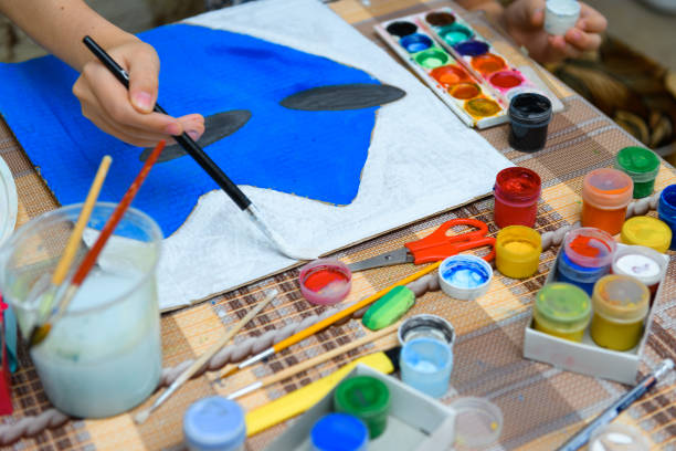 istock a girl drawing blue gouache cardboard, artistic creation at home, makes creative artwork 1295949255