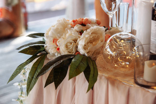 istock White flowers with candles on the table, wedding rustic decor 1295949619