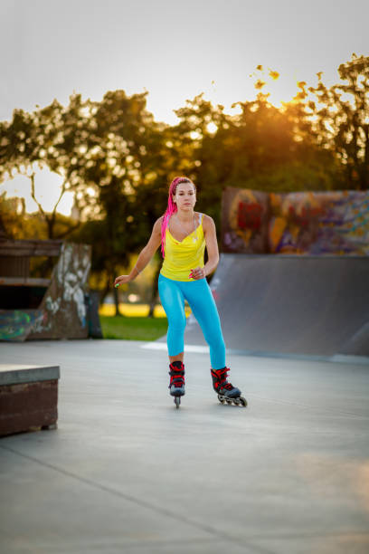 istock Young woman skating on rollers in skate park 1295952747