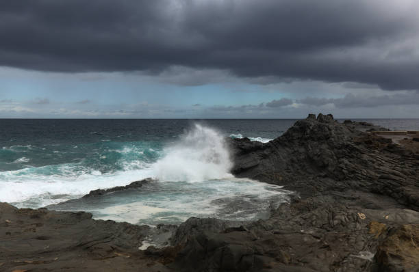 dark storm waves crushing at the beach on maui island, hawaii islands, usa.