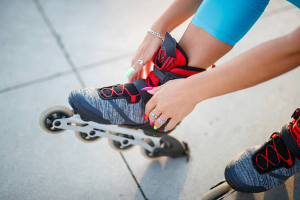 istock Female manicured hands tying laces on roller blades 1295952765