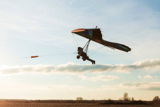 istock Beginner hang glider wing silhouette on the sunset sky 1295954420