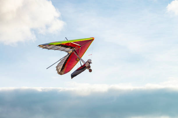 istock Colorful beginner hang glider wing silhouette with blue sky on the background. 1295954450
