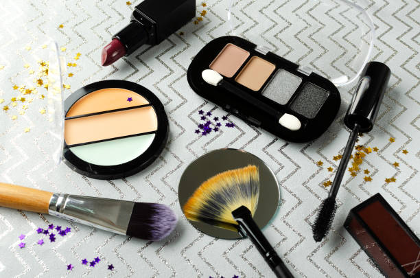 istock Closeup of concealer, eyeshadows and brushes for makeup, glitter on the grey surface 1295954600