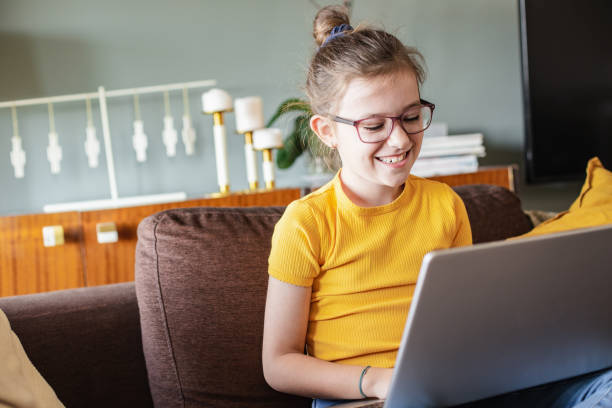 istock Little girl is using laptop at home 1295955500
