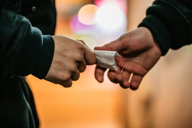 Man Buying Drugs On The Street Addict young man have meeting with dealer at night to buy dose of white powder cocaine. drug dealer stock pictures, royalty-free photos & images