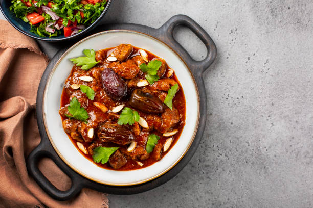 traditional moroccan lamb tagine simmered in spices, with dates and almonds. - lamb shank dinner meal imagens e fotografias de stock