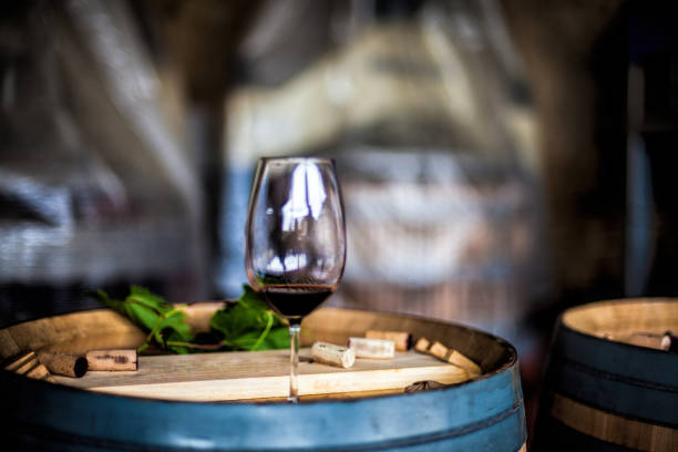 istock Glass of red wine on a wine barrel 1295959965