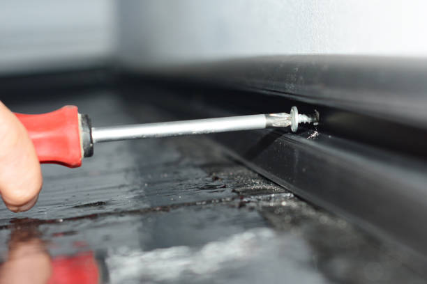 istock A close-up on a man hand installing black pvc plastic skirting board  for concealing cables using a screwdriver. 1295960408
