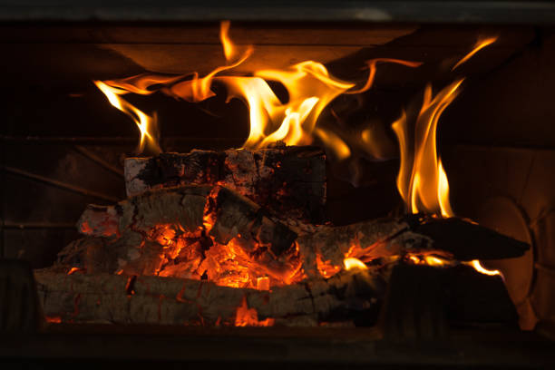 Logs burning in the fire of a fireplace with embers