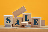 wooden blocks with the wordings SALE, isolated against yellow background
