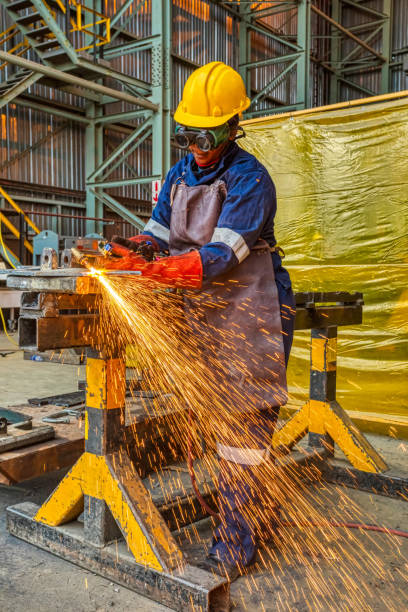 istock Woman African worker with red gloves  cutting with a torch 1295962868