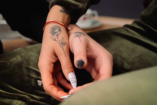 An enlarged photo of the hands of two lesbian girls with the same tattoos. High quality photo