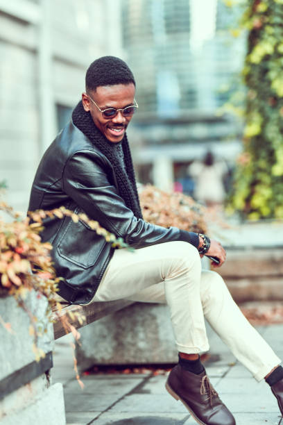 istock Elegant African Male Sitting Outside On Bench 1295964439