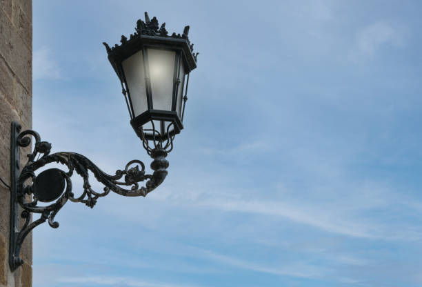 istock iron street lamp lit with blue sky background 1295964993
