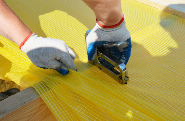 istock A building contractor is installing vapor barrier, plastic sheeting stapling it to ceiling joists constructing a pitched roof with mineral wool insulation. 1295966454