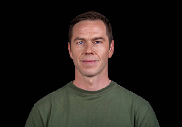 Close-up of mature man Portrait of mature man standing against black background. olive green shirt stock pictures, royalty-free photos & images