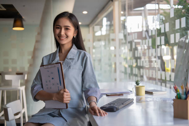 istock Portrait of a female entrepreneur looking into the camera while working with a computer in an office room. 1295969247