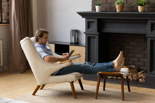 istock Young Caucasian man relax in chair using tablet 1295970353