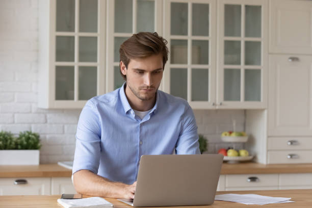 istock Young Caucasian man work online on laptop at home 1295970462