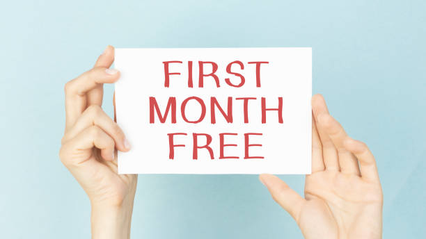 istock hands hold card with First month free text 1295971196