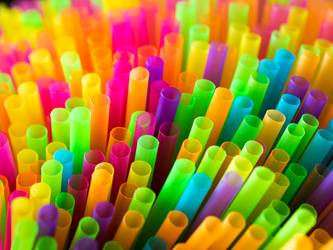 Extreme close up macro color image depicting a large collection of multi colored drinking straws, forming a vibrant and colorful abstract background.