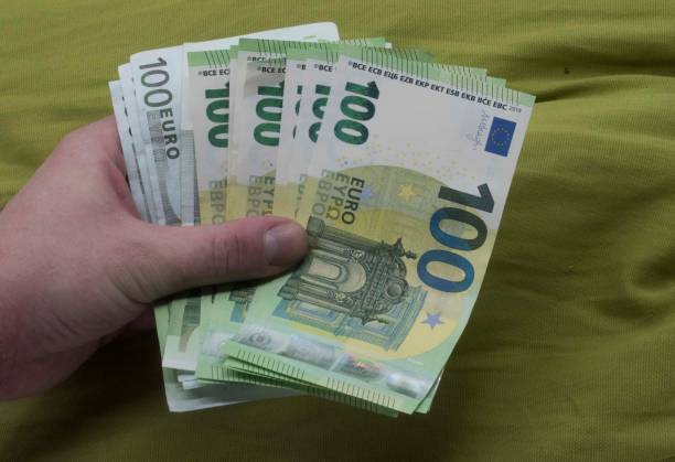 istock holding one hundred euro bills in hand 1295976521