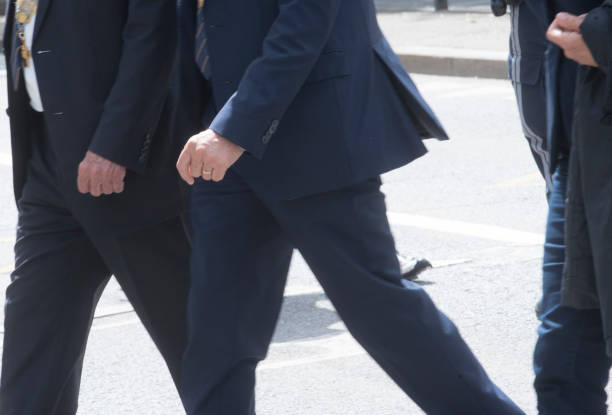 istock man in suit walking on the street 1295976529