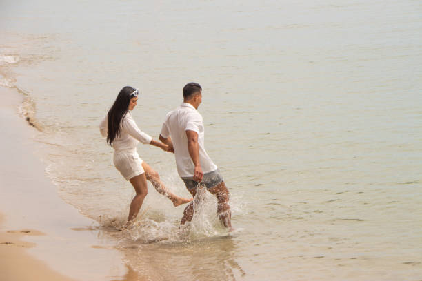 father mather dougther playing together sea water