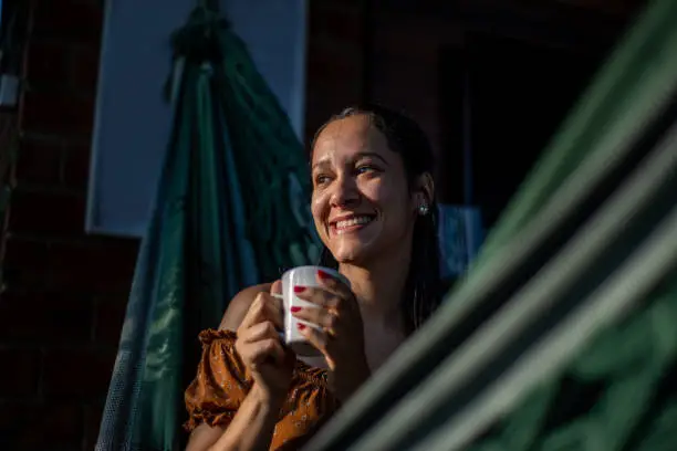 Photo of Relaxed young woman having a cup of coffee
