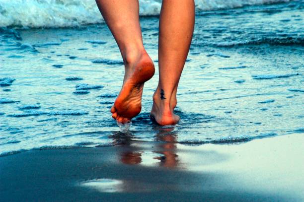 istock human walking barefoot at the beach 1295977223