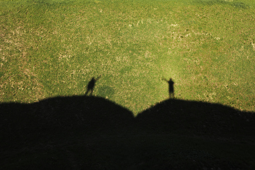 Shadow of lovers on the green hills on summer sunny day. Lovely summer landscape.