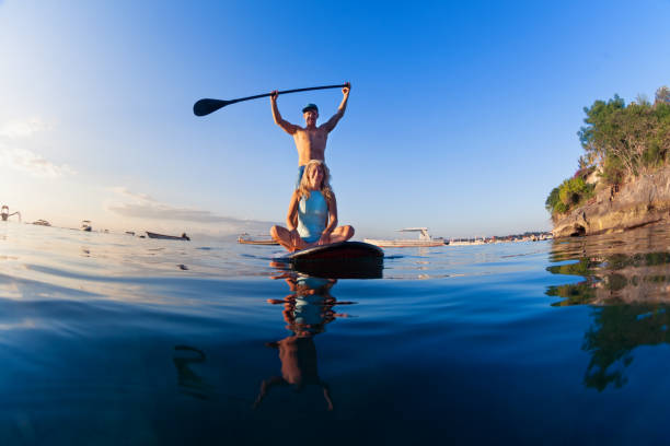 istock Young happy couple have fun on stand up paddleboard 1295978379
